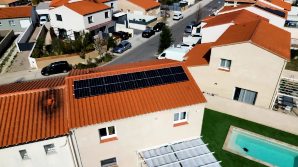 Vue aérienne d’une maison équipée de panneaux solaires dans un lotissement