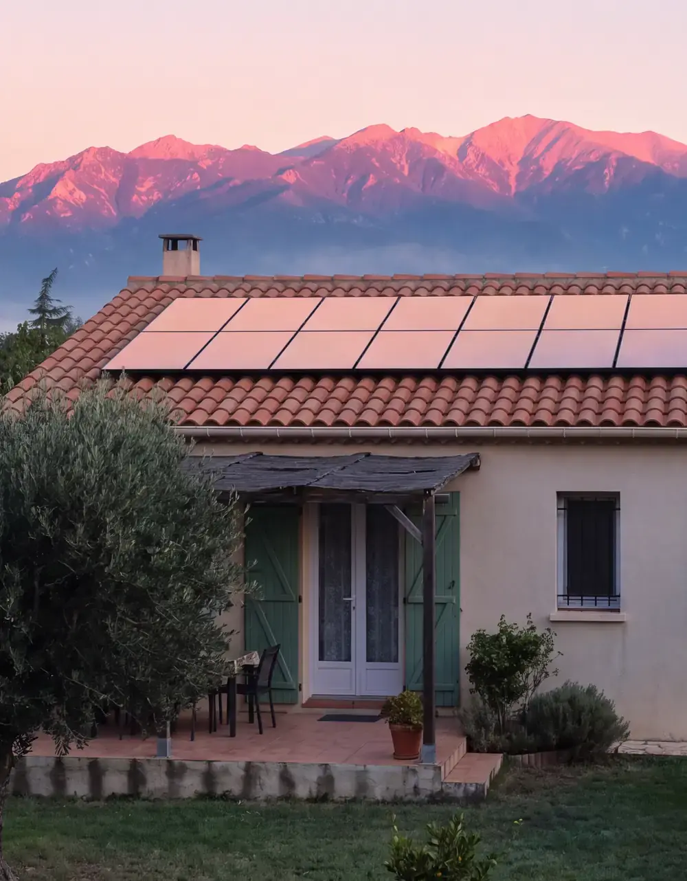 Maison équipée de panneaux solaires face au Canigou rosi par l’aube